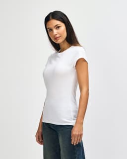 A fitted white ladies' T-shirt displayed on a model, paired with blue denim jeans. The shirt has a logo.