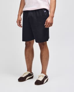 A pair of black cotton gym shorts with an elastic waistband and logo branding.