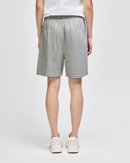 Grey cotton gym shorts with an elastic waistband and a logo, viewed from the back.