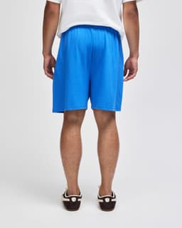 Blue cotton gym shorts with an elastic waistband, featuring a logo on the side.