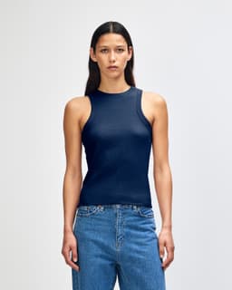 A fitted women's tank top in navy blue, featuring a ribbed design and a logo on the side.