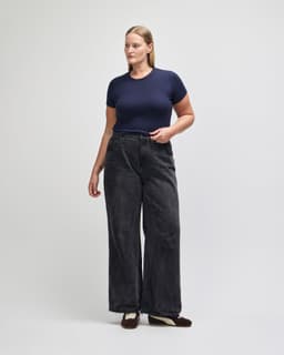 A fitted navy blue women's crop t-shirt paired with high-waisted black wide-leg jeans.