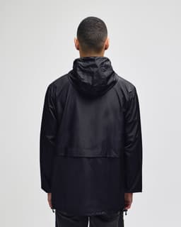 A black full-zip anorak jacket with a hood, featuring a simple design and a logo. Back view of the jacket.