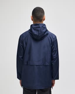 A navy full-zip anorak jacket with a hood and a back vent, featuring a logo.