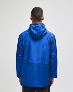 A blue Champion Adult Full-Zip Anorak Jacket viewed from the back, featuring a hood and a logo.