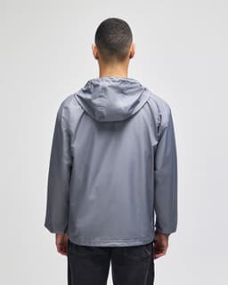 A grey packable anorak jacket viewed from the back, featuring a hood and a minimalist design.