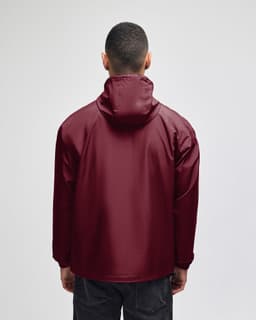 A maroon packable anorak jacket with a hood, viewed from the back, featuring a logo.