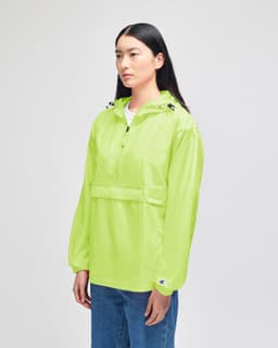 A bright green packable anorak jacket with a hood and a front pocket, featuring a logo.