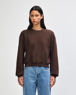A brown women's crewneck sweatshirt made from fleece, featuring long sleeves and a relaxed fit.