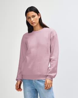 A unisex crewneck sweatshirt in light pink, featuring a relaxed fit and long sleeves. It has a logo on the front.