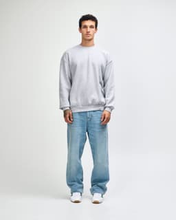 A grey unisex crewneck sweatshirt displayed on a model wearing black cargo pants and sneakers.