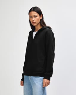 A black unisex full zip hooded sweatshirt displayed on a model, featuring a hood and front pockets.