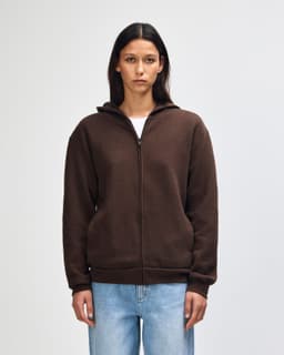A unisex full zip hooded sweatshirt in dark brown, featuring a hood and a simple design. Includes branding.
