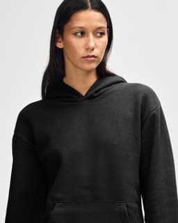 A black unisex hooded sweatshirt with a front pocket and a relaxed fit. It features a logo on the garment.