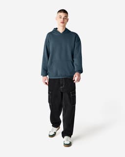A unisex hooded sweatshirt in dark grey, featuring a front pocket and an attached hood, paired with cargo pants.
