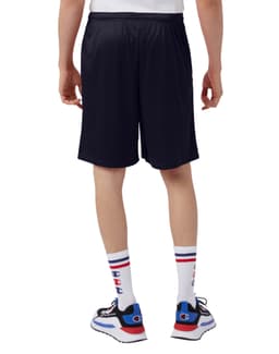 A person wearing navy Champion adult mesh shorts with pockets, viewed from the back, paired with stylish shoes and socks.