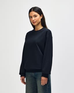 A black Gildan Softstyle adult sweatshirt displayed on a model, featuring a simple design and a logo.