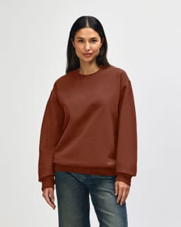 A brown Gildan Softstyle adult sweatshirt displayed on a model, featuring a classic crew neck and long sleeves.