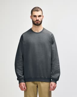A green sweatshirt is displayed, featuring a classic crew neck and ribbed cuffs, with a logo on the front.
