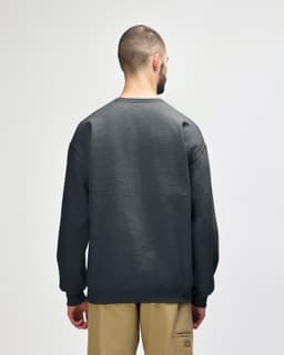 A green Gildan Softstyle adult sweatshirt viewed from the back, featuring a simple design and loose fit.