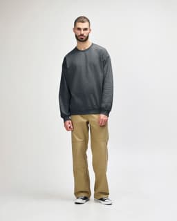 A green Gildan Softstyle adult sweatshirt displayed on a model, paired with black pants and sneakers.