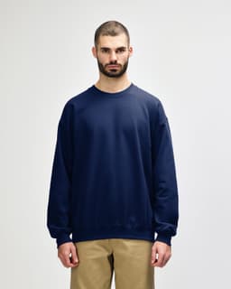 A navy Gildan Softstyle adult sweatshirt with a crew neckline and long sleeves. Features a logo on the chest.