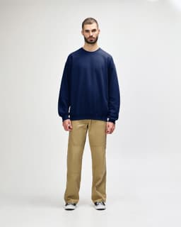 A navy blue Gildan Softstyle adult sweatshirt, shown on a model paired with black pants and sneakers.