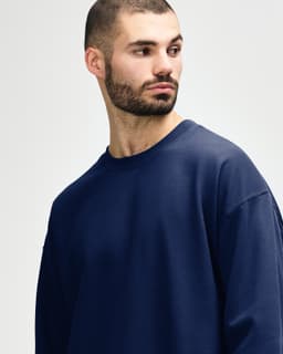 A navy Gildan Softstyle adult sweatshirt featuring a crew neck and long sleeves, with a logo on the sleeve.