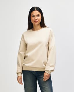 A cream-coloured Gildan Softstyle adult sweatshirt displayed on a model, featuring long sleeves and a crew neckline.