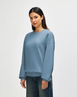 A soft blue sweatshirt with a crew neckline and long sleeves, featuring a logo on the chest.