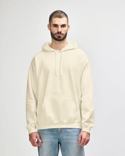 A cream-coloured hooded sweatshirt on a model, featuring a front pocket and a logo on the sleeve.