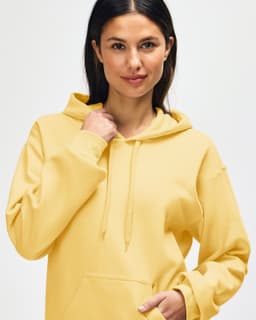 A yellow Gildan Softstyle adult hooded sweatshirt with a kangaroo pocket and a hood. The model has a relaxed expression.