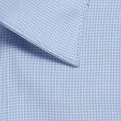 A button-up shirt with a light blue puppytooth pattern and a sharply pointed collar. It features a logo.