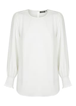 A white blouse with a round neckline, shirred cuffs, and long sleeves. It features a subtle, elegant style and has a branding label.