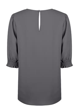 A grey blouse with shirred cuffs and a keyhole back detail. It features short, puffed sleeves and a smooth finish.