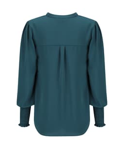 A long sleeve top in deep teal with gathered sleeves and a pleat detail at the back, featuring a branding logo.