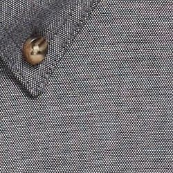 A close-up of a textured grey work shirt featuring a button and collar detail.