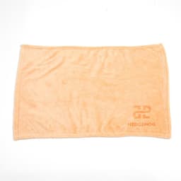 An orange flannel fleece blanket featuring a logo in the corner. Soft and plush texture.