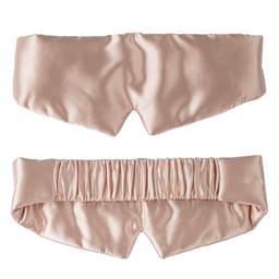 A satin silk sleep mask in a soft pink hue with an elastic band at the back and a smooth finish.