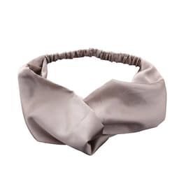 A crisscross headband in a soft beige hue, featuring a stretchy band for a comfortable fit.