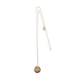 A gold adjustable necklace featuring a round pendant with a logo. The chain is delicate and includes an extension.