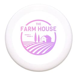 A white frisbee featuring a pink logo with farm-themed graphics and text. Suitable for outdoor fun and games.