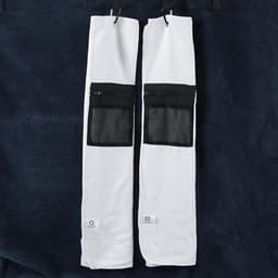 A golf towel in white with a black zippered pocket, featuring a textured fabric. Two towels are displayed together.
