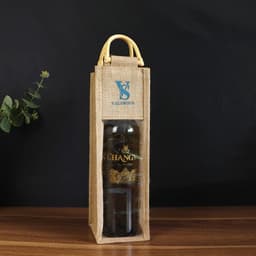 A drink bottle packaged in a natural jute wine bag with a clear window and yellow handle. Features a logo on the front.