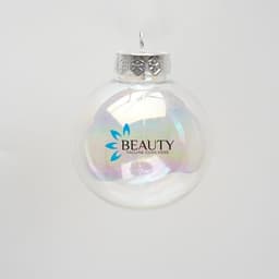 A clear iridescent plastic ball ornament with a silver top and a logo on the surface.