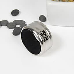 A stainless steel wine drip ring with a smooth finish, featuring a black interior and a design area, surrounded by pebbles.