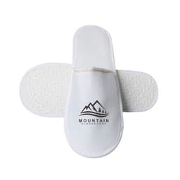 White hotel slippers with an anti-slip sole, featuring a logo and a textured design on the base.