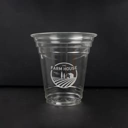 A clear 12 oz. biodegradable disposable PLA cup with a branded logo design.