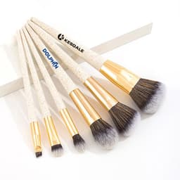 A biodegradable wheat straw makeup brush set featuring five brushes with gold detailing and soft bristles.