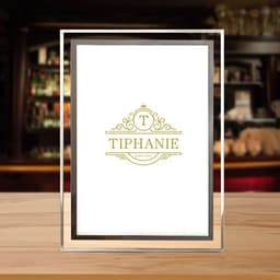 A crystal glass photo frame with a gold logo design on a white background, showcasing a stylish, elegant appearance.